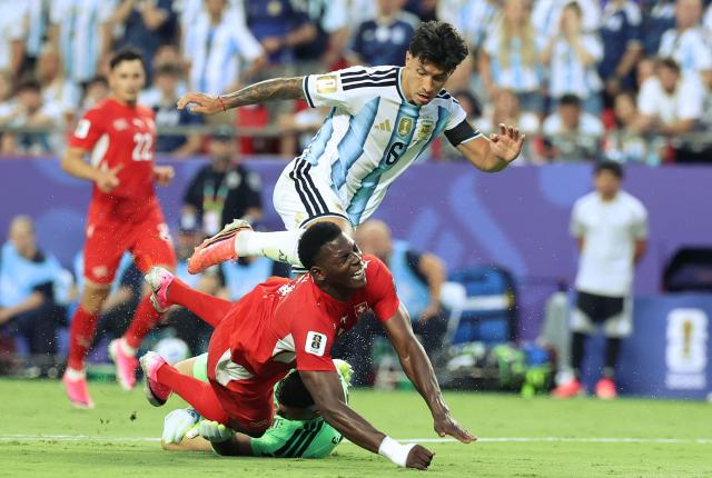 Switzerland's forward #07 Breel Embolo trips over Argentina's goalkeeper #23 Emiliano Martinez as Argentina's defender #06 Lisandro Martinez looks on during the 2026 World Cup football tournament quarter-final match between Argentina and Switzerland at the Kansas City Stadium in Kansas City on July 11, 2026.  (Photo by Thomas COEX / AFP)