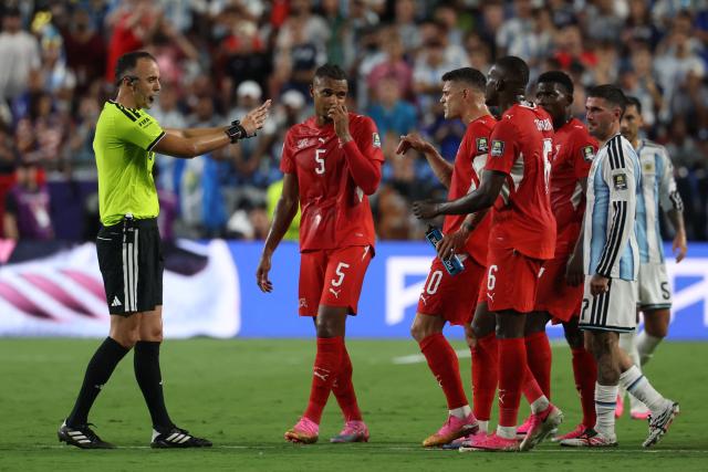 Switzerland's players argue with Portuguese referee Joao Pinheiro before he shows a second yellow card to Switzerland's forward #07 Breel Embolo (2nd-R) during the 2026 World Cup football tournament quarter-final match between Argentina and Switzerland at the Kansas City Stadium in Kansas City on July 11, 2026.  (Photo by Odd ANDERSEN / AFP)