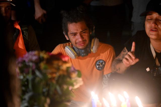 Volunteers, rescuers and residents light candles during a vigil in front of the rubble of the collapsed Obras del Poder Popular (OPP) building in Caraballeda, La Guaira state, Venezuela, on July 11, 2026, following twin earthquakes that struck the region. The death toll from the twin earthquakes that struck Venezuela on June 24 has risen to more than 4,300, National Assembly President Jorge Rodriguez said on July 11. (Photo by Juan BARRETO / AFP)
