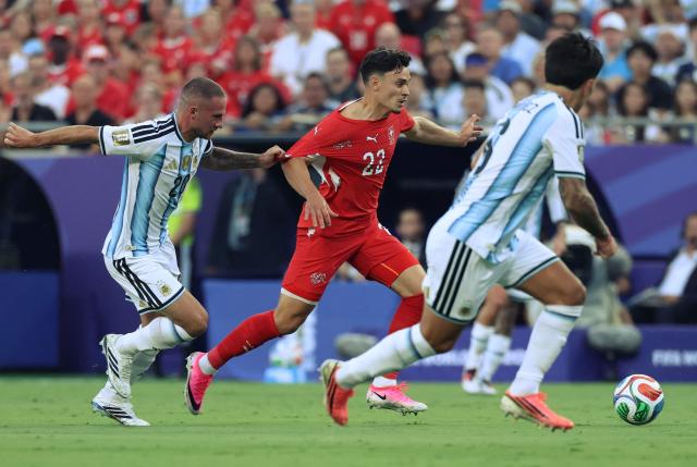 Switzerland's forward #22 Fabian Rieder is slowed by Argentina's midfielder #20 Alexis Mac Allister while running with the ball during the 2026 World Cup football tournament quarter-final match between Argentina and Switzerland at the Kansas City Stadium in Kansas City on July 11, 2026.  (Photo by Thomas COEX / AFP)