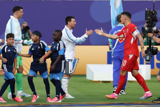 Argentina's forward #10 Lionel Messi (C) and Switzerland's midfielder #10 Granit Xhaka greet each other before the start of the 2026 World Cup football tournament quarter-final match between Argentina and Switzerland at the Kansas City Stadium in Kansas City on July 11, 2026.  (Photo by Odd ANDERSEN / AFP)