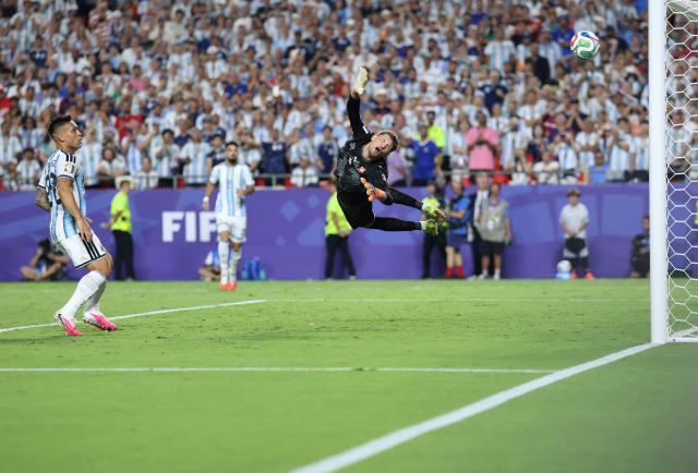 Switzerland's goalkeeper #01 Gregor Kobel dives but fails to save a goal scored by Argentina's forward #09 Julian Alvarez (unseen) as Argentina's forward #22 Lautaro Martinez looks on during the 2026 World Cup football tournament quarter-final match between Argentina and Switzerland at the Kansas City Stadium in Kansas City on July 11, 2026.  (Photo by Thomas COEX / AFP)