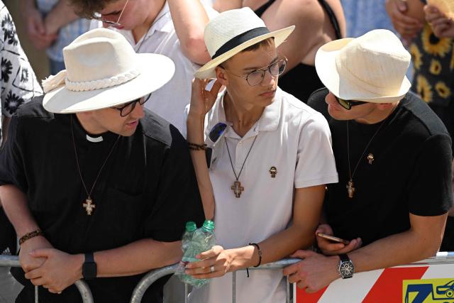 People stand in the heat as Pope Leo XIV leads the Angelus prayer from the entrance of the Apostolic Palace in Piazza della Liberta (Liberty Square) at the summer papal residence in Castel Gandolfo on 12 July 2026. (Photo by Tiziana FABI / AFP)