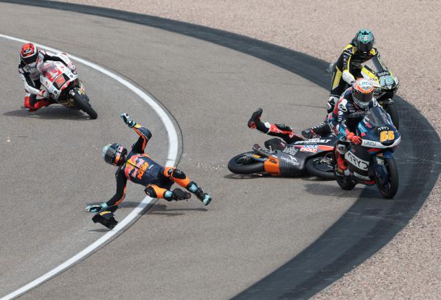 Red Bull KTM Tech3 Team's Argentinian driver Valentin Perrone (2nd L) and another unidentified driver crash during the Moto3 race at the Sachsenring race track in Hohenstein-Ernstthal near Chemnitz, eastern Germany, on July 12, 2026, ahead of the German Motorcycle MotoGP Grand Prix. (Photo by Ronny HARTMANN / AFP)