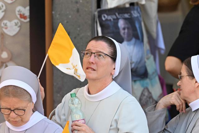 Nuns wait for Pope Leo XIV Angelus prayer in front of the entrance of the Apostolic Palace in Piazza della Liberta (Liberty Square) at the summer papal residence in Castel Gandolfo on 12 July 2026. (Photo by Tiziana FABI / AFP)