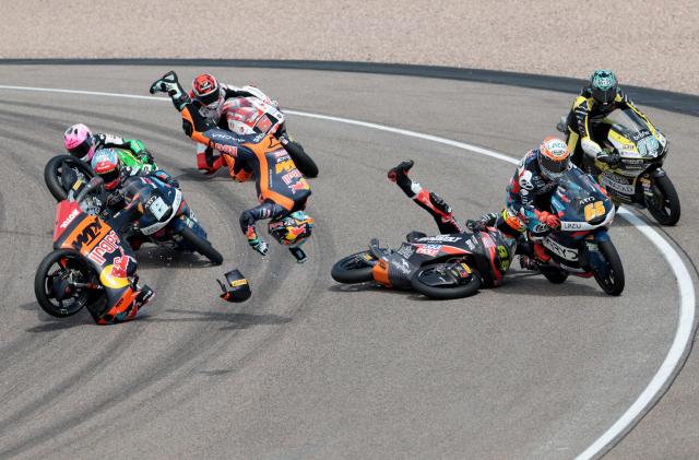 Red Bull KTM Tech3 Team's Argentinian driver Valentin Perrone (L, flying head over heels through the air) and another unidentified driver crash during the Moto3 race at the Sachsenring race track in Hohenstein-Ernstthal near Chemnitz, eastern Germany, on July 12, 2026, ahead of the German Motorcycle MotoGP Grand Prix. (Photo by Ronny HARTMANN / AFP)