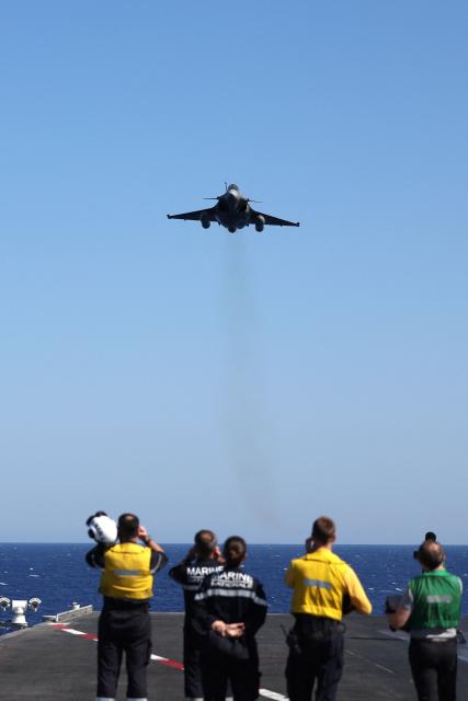 A Marine Rafale fighter aircraft flies over the deck of the Charles de Gaulle aircraft carrier as it returns from its 'Lafayette 26' mission near Bonifacio off the coast of the French island of Corsica, southern France on July 10, 2026. (Photo by Pascal POCHARD-CASABIANCA / AFP)