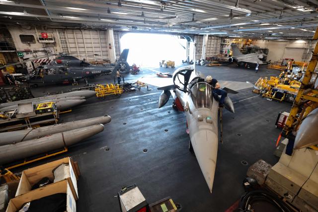 A French Navy officer works on a Marine Rafale fighter aircraft on the hangar deck of the Charles de Gaulle aircraft carrier as it returns from its 'Lafayette 26' mission near Bonifacio off the coast of the French island of Corsica, southern France on July 9, 2026. (Photo by Pascal POCHARD-CASABIANCA / AFP)