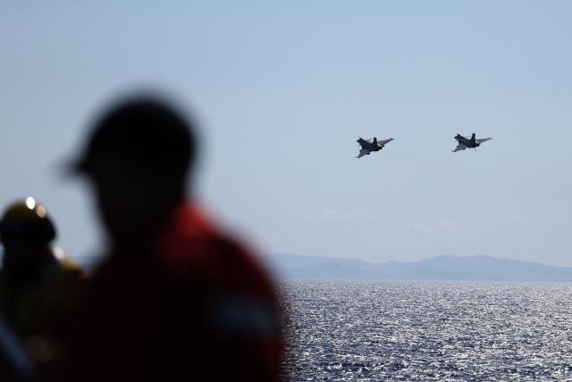 Two Marine Rafale fighter aircrafts fly past the Charles de Gaulle aircraft carrier as it returns from its 'Lafayette 26' mission near Bonifacio off the coast of the French island of Corsica, southern France on July 10, 2026. (Photo by Pascal POCHARD-CASABIANCA / AFP)