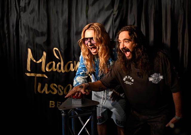 German musician Bill Kaulitz (L) and his twin brother Tom Kaulitz (R) from the German band "Tokio Hotel" press a button to officially launch the display of their wax likenesses during the unveiling of their figures at Madame Tussauds wax museum in Berlin on July 12, 2026. (Photo by Tobias SCHWARZ / AFP)