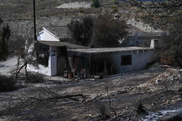 A house damaged by fire from a wildfire that killed at least 12 people, is seen in Almocaizar, Almeria Province, on July 12, 2026. A wildfire that has killed at least 12 people in southern Spain was close to being brought under control Sunday, allowing hundreds of evacuated residents to return home as firefighters worked to fully stabilise the blaze, offficials said. Authorities have kept the death toll at 12 and cautioned that the number of missing people remains uncertain until autopsies and the identification of recovered bodies are completed. (Photo by JOSE JORDAN / AFP)