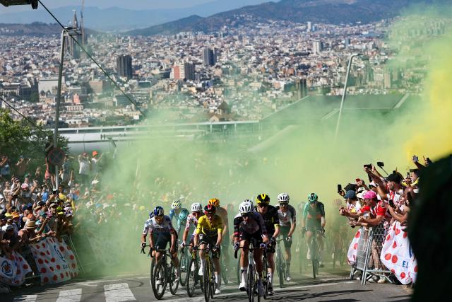 UAE Team Emirates - XRG's Slovenian rider Tadej Pogacar wearing the climber's dotted jersey and Team Visma | Lease a Bike's Danish rider Jonas Vingegaard wearing the overall leader's yellow jersey and riders emerge from yellow smoke as they cycle in the Montjuic Palace ascent in the final kilometers of the 2nd stage of the 113th edition of the Tour de France cycling race, 168,5 km between Tarragona and Barcelona in northeastern Spain, on July 5, 2026. (Photo by Anne-Christine POUJOULAT / AFP)