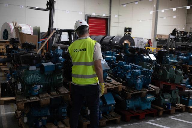 A member of the French customs services records obsolete industrial air conditioning parts seized in containers in a warehouse of the northwestern harbour of Le Havre on July 8, 2026. (Photo by Alain JOCARD / AFP)