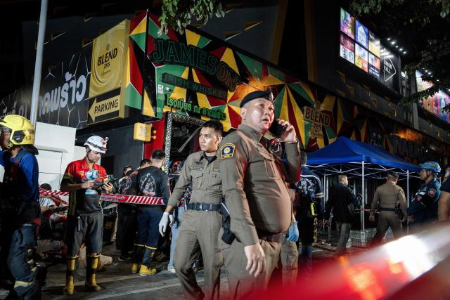 Police stands guard after a massive fire engulfed a bar in Bangkok, early on July 13, 2026. A fire in a bar in the Thai capital Bangkok killed at least 27 people late Sunday night, Prime Minister Anutin Charnvirakul told local media. (Photo by chanakarn LAOSARAKHAM / AFP)