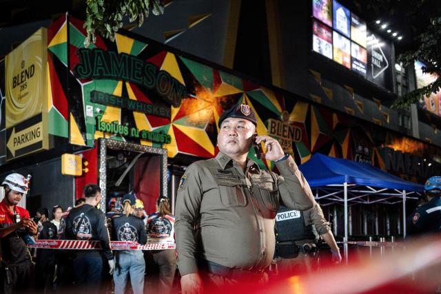 Police stand guard after a massive fire engulfed a bar in Bangkok, early on July 13, 2026. A fire in a bar in the Thai capital Bangkok killed at least 27 people late Sunday night, Prime Minister Anutin Charnvirakul told local media. (Photo by chanakarn LAOSARAKHAM / AFP)