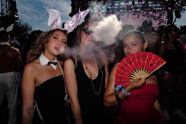 People pose as they arrive to attend the "Bal des fous" festive event at the Palais des Festivals in Cannes, French Riviera, on July 12, 2026. (Photo by Valery HACHE / AFP)