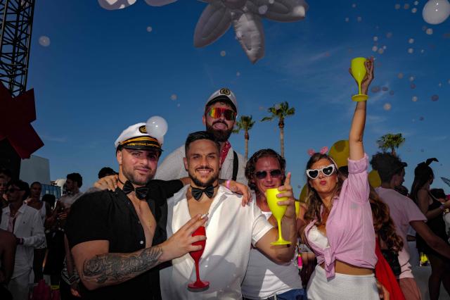 People pose as they arrive to attend the "Bal des fous" festive event at the Palais des Festivals in Cannes, French Riviera, on July 12, 2026. (Photo by Valery HACHE / AFP)
