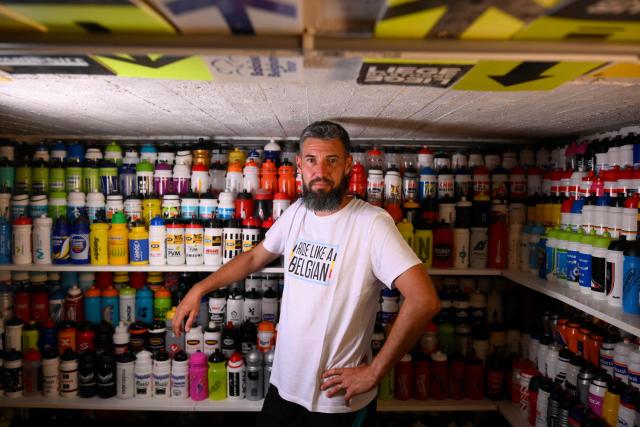 Cycling enthusiast Cedric Raemmackers poses with his collection of around 6,000 cyclists' hydration bottles which he has been collecting since 1992, in his home in Wanze, on June 22, 2026. (Photo by JOHN THYS / AFP)