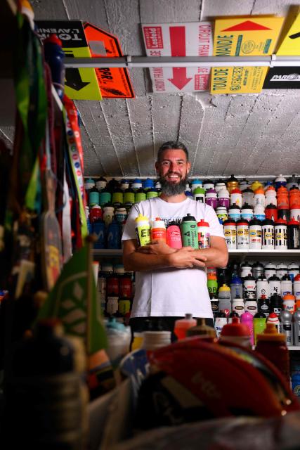 Cycling enthusiast Cedric Raemmackers poses with his collection of around 6,000 cyclists' hydration bottles which he has been collecting since 1992, in his home in Wanze, on June 22, 2026. (Photo by JOHN THYS / AFP)