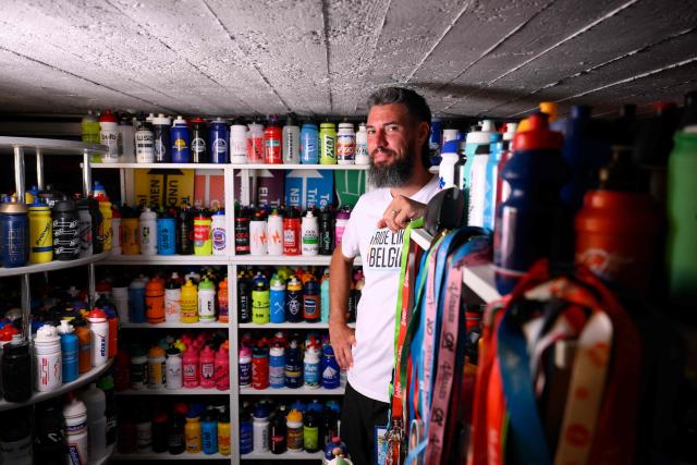 Cycling enthusiast Cedric Raemmackers poses with his collection of around 6,000 cyclists' hydration bottles which he has been collecting since 1992, in his home in Wanze, on June 22, 2026. (Photo by JOHN THYS / AFP)