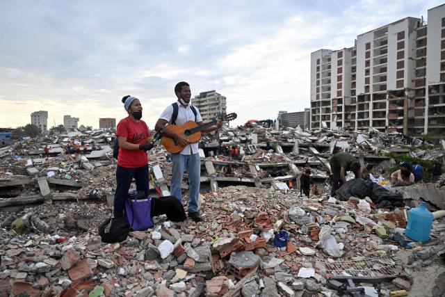 TOPSHOT - Residents sing Christian worship songs amid the rubble of the Obras del Poder Popular (OPP) building in Caraballeda, La Guaira state, Venezuela, on July 12, 2026, following twin earthquakes that struck the region. The twin earthquakes that struck Venezuela on June 24 had left nearly 4,500 people dead as of July 12, while much of the affected population continued to live in camps, according to official figures. (Photo by Juan BARRETO / AFP)