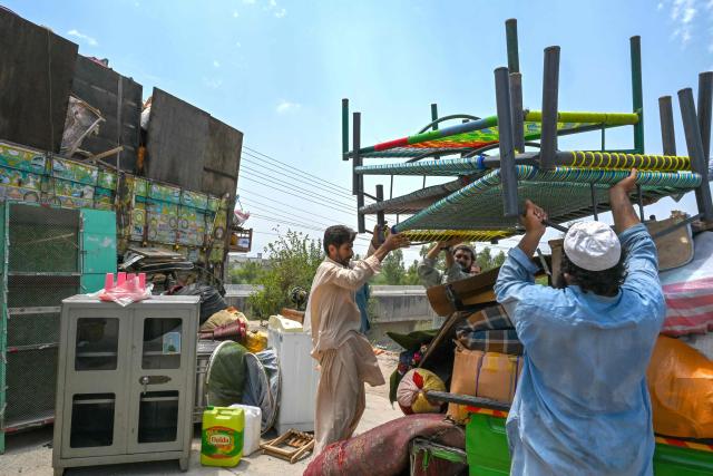 Afghan refugees load their belongings onto a truck in Peshawar on July 13, 2026, as they prepare to depart for Afghanistan. (Photo by Abdul MAJEED / AFP)