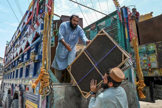 Afghan refugees load their belongings onto a truck in Peshawar on July 13, 2026, as they prepare to depart for Afghanistan. (Photo by Abdul MAJEED / AFP)