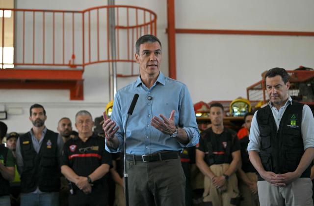 Spain's Prime Minister Pedro Sanchez talks to media next to Andalusian regional president Juan Manuel Moreno (R) after a wildfire that killed at least 13 people, at the command post set in Turre, Almeria Province, on July 13, 2026. The toll from the deadly wildfires in southern Spain rose to 13 on July 12, 2026 after a British woman died of her injuries in hospital, officials in Andalusia region announced. (Photo by JORGE GUERRERO / AFP)