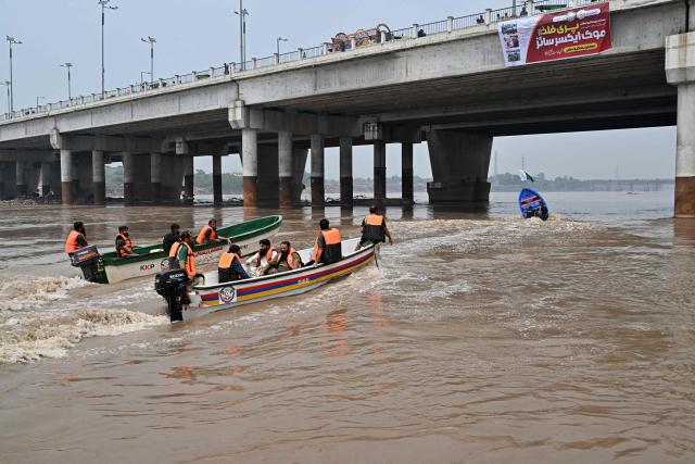 Relief personnel conduct a flood rescue drill during monsoon season as a precautionary measure at the Ravi river in Lahore on July 13, 2026. (Photo by Arif ALI / AFP)