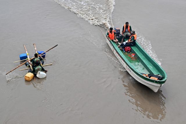 Relief personnel conduct a flood rescue drill during monsoon season as a precautionary measure at the Ravi river in Lahore on July 13, 2026. (Photo by Arif ALI / AFP)