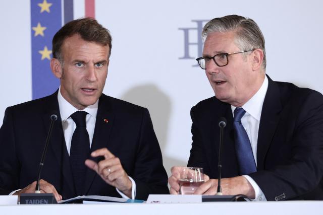 France's President Emmanuel Macron (L) and Britain's Prime Minister Keir Starmer take part in a summit of the Coalition of the Willing to support Ukraine at the Hotel des Invalides in Paris on July 13, 2026. The summit meeting of the Coalition of the Willing -- launched by France and the United Kingdom to provide military support to Ukraine after Russia's full-scale invasion -- will push for a ceasefire and renewed peace talks, the French presidency said. (Photo by Teresa Suarez / POOL / AFP)