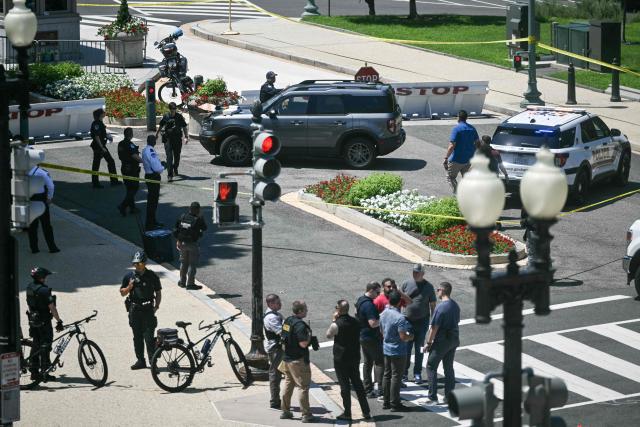 US Capitol Police officers and security personnel surround a vehicle that approached a security barricade near Constitution Avenue outside the US Capitol in Washington, DC, on July 13, 2026.  (Photo by Brendan SMIALOWSKI / AFP)