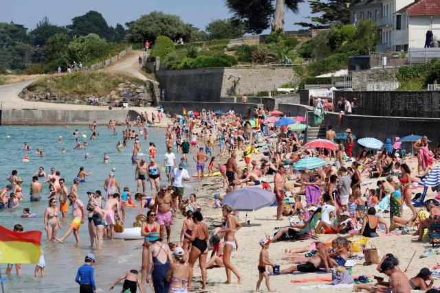 People enjoy the beach in Douarnenez, Brittany, on July 13, 2026, as France is weathering a third heatwave in less than three months. (Photo by Fred TANNEAU / AFP)