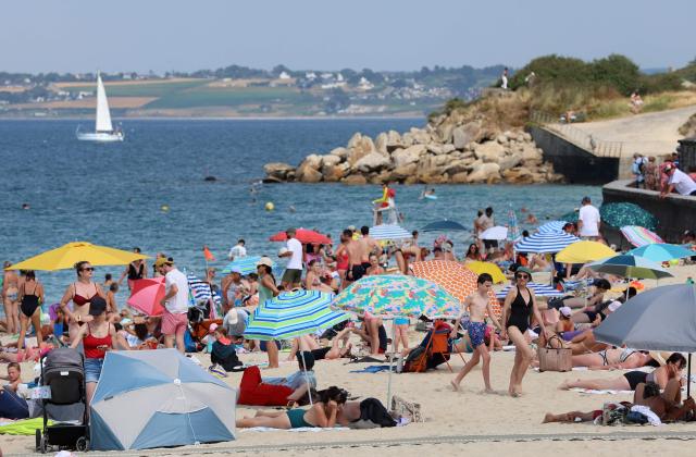 People enjoy the beach in Douarnenez, Brittany, on July 13, 2026, as France is weathering a third heatwave in less than three months. (Photo by Fred TANNEAU / AFP)