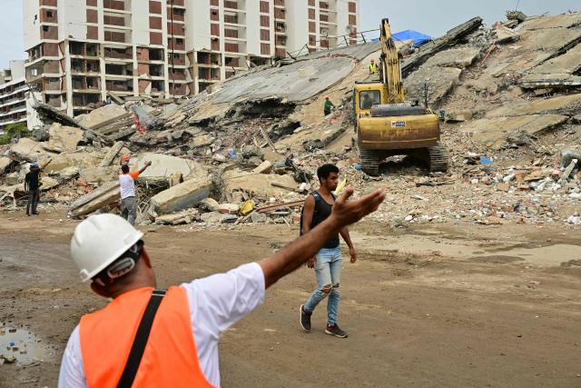 An excavator operates during search and recovery efforts at the site of a collapsed building in Caraballeda, La Guaira state, Venezuela, on July 13, 2026, following twin earthquakes that struck the region. The official death toll from Venezuela's devastating twin earthquakes rose to nearly 4,500 on July 12, 2026, as the government reported more than 19,500 people were now living in camps due to the destruction. (Photo by MARTIN BERNETTI / AFP)