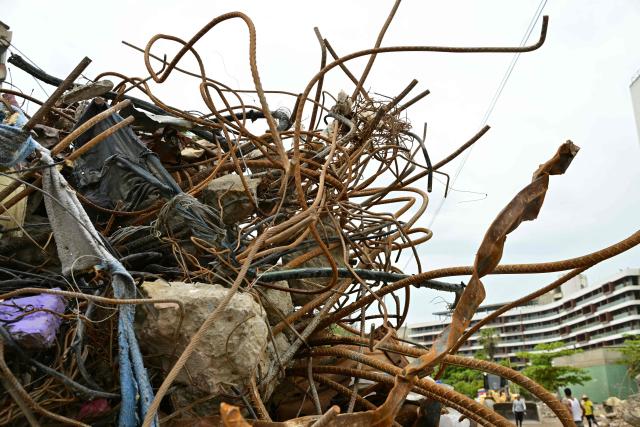 Twisted steel reinforcement bars protrude from the rubble of a collapsed building in Caraballeda, La Guaira state, Venezuela, on July 13, 2026, following twin earthquakes that struck the region. The official death toll from Venezuela's devastating twin earthquakes rose to nearly 4,500 on July 12, 2026, as the government reported more than 19,500 people were now living in camps due to the destruction. (Photo by MARTIN BERNETTI / AFP)