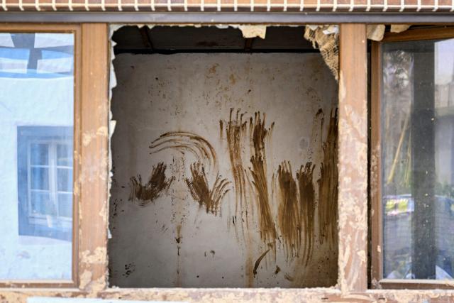 A photo shows handprints smeared with mud on a wall at a uninhabited house in Schuld, western Germany on July 13, 2026, five years after the dramatic floods of July 14 and 15, 2021 in Rhineland-Palatinate and North Rhine-Westphalia. More than 180 people lost their lives in severe floods that pummelled western Germany in mid-July 2021, raising questions about whether enough was done to forewarn residents. (Photo by Ina FASSBENDER / AFP)