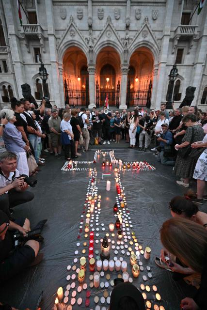 Supporters of the former ruling party, FIDESZ, protest the amendment to the Fundamental Law with a candlelight at Kossuth Lajos Square, in front of the parliament building in Budapest, Hungary on July 13, 2026. The Hungarian parliament on on July 13, 2026 passed a constitutional tweak to oust the country's president, whom new Prime Minister Peter Magyar accuses of being a "puppet" of hardline ex-leader Viktor Orban. Lawmakers from Magyar's Tisza party broke into a half-minute-long standing ovation after voting to eject unpopular President Tamas Sulyok from office by 139 votes to six, in a ballot boycotted by Orban's nationalist Fidesz party. (Photo by Attila KISBENEDEK / AFP)