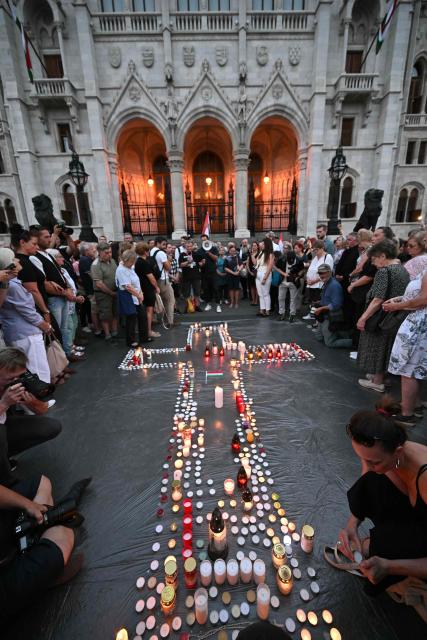 Supporters of the former ruling party, FIDESZ, protest the amendment to the Fundamental Law with a candlelight at Kossuth Lajos Square, in front of the parliament building in Budapest, Hungary on July 13, 2026. The Hungarian parliament on on July 13, 2026 passed a constitutional tweak to oust the country's president, whom new Prime Minister Peter Magyar accuses of being a "puppet" of hardline ex-leader Viktor Orban. Lawmakers from Magyar's Tisza party broke into a half-minute-long standing ovation after voting to eject unpopular President Tamas Sulyok from office by 139 votes to six, in a ballot boycotted by Orban's nationalist Fidesz party. (Photo by Attila KISBENEDEK / AFP)