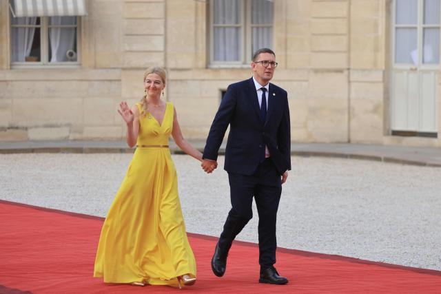 Estonia's Prime Minister Kristen Michal (R) and his wife Evelin Oras (L) arrive for a dinner of the Coalition of the Willing to support Ukraine at The Elysee Presidential Palace in Paris on July 13, 2026. Macron is convening a summit in Paris of the Coalition of the Willing to support Ukraine - launched by France and the United Kingdom to provide military support to Ukraine after Russia's full-scale invasion - that will be attended by Ukraine's President, signaling the "strategic awakening" he seeks for Europe in the face of Russia and United States. (Photo by Ludovic MARIN / AFP)