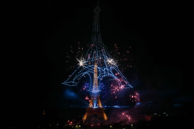 Fireworks light up around the Eiffel Tower during a choreographed firework and drone show to celebrate Bastille Day, in Paris, on July 13, 2026, on the eve of the annual Bastille Day Parade in the French capital. (Photo by LOU BENOIST / AFP)