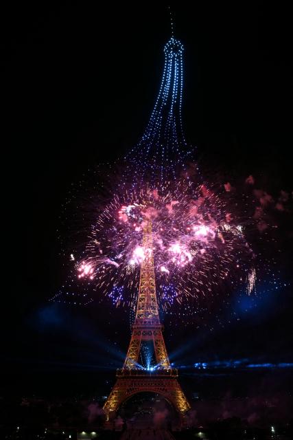 Fireworks light up around the Eiffel Tower during a choreographed firework and drone show to celebrate Bastille Day, in Paris, on July 13, 2026, on the eve of the annual Bastille Day Parade in the French capital. (Photo by LOU BENOIST / AFP)