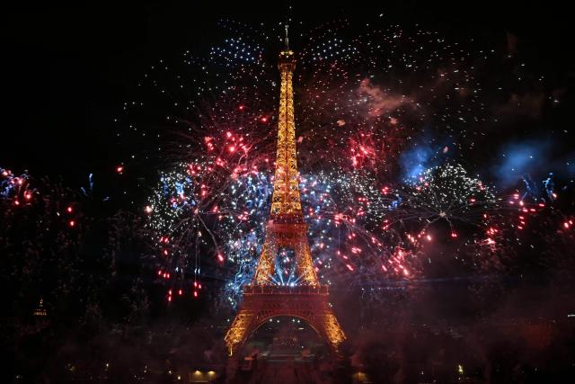 Fireworks light up around the Eiffel Tower during a choreographed firework and drone show to celebrate Bastille Day, in Paris, on July 13, 2026, on the eve of the annual Bastille Day Parade in the French capital. (Photo by LOU BENOIST / AFP)