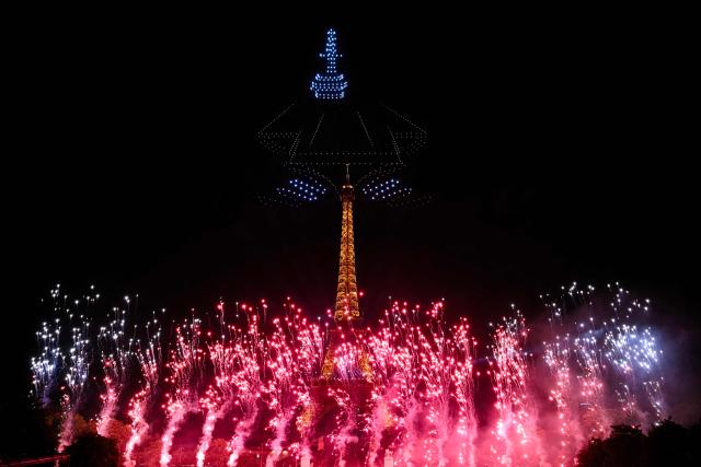 Drones display an aircraft carrier during a choreographed firework and drone show to celebrate Bastille Day, in Paris, on July 13, 2026, on the eve of the annual Bastille Day Parade in the French capital. (Photo by LOU BENOIST / AFP)