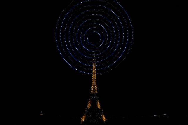 This photograph shows the Eiffel Tower during a choreographed firework and drone show to celebrate Bastille Day, in Paris, on July 13, 2026, on the eve of the annual Bastille Day Parade in the French capital. (Photo by LOU BENOIST / AFP)