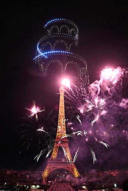 Fireworks light up around the Eiffel Tower during a choreographed firework and drone show to celebrate Bastille Day, in Paris, on July 13, 2026, on the eve of the annual Bastille Day Parade in the French capital. (Photo by LOU BENOIST / AFP)