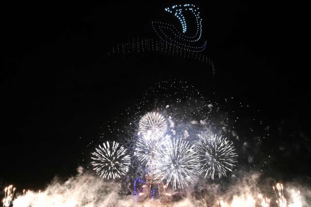 Fireworks light up around the Eiffel Tower during a choreographed firework and drone show to celebrate Bastille Day, in Paris, on July 13, 2026, on the eve of the annual Bastille Day Parade in the French capital. (Photo by LOU BENOIST / AFP)
