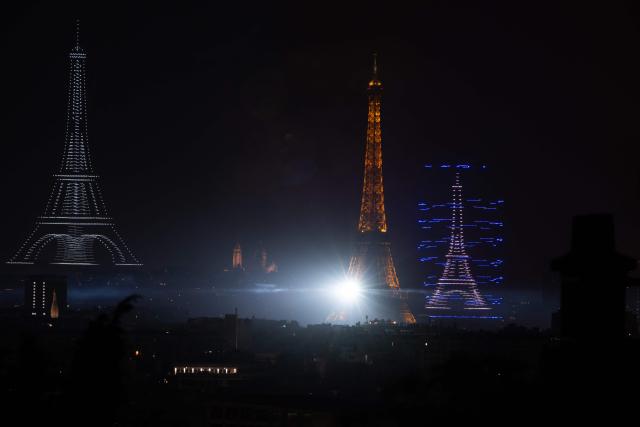 TOPSHOT - Fireworks light up around the Eiffel Tower during a choreographed firework and drone show to celebrate Bastille Day, in Paris, on July 13, 2026, on the eve of the annual Bastille Day Parade in the French capital. (Photo by Martin BUREAU / AFP)