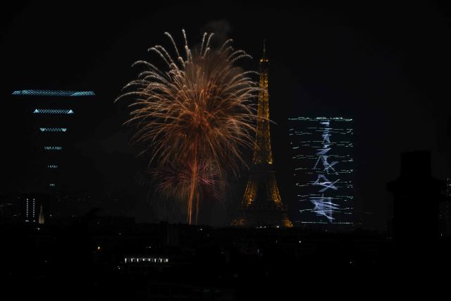 Fireworks light up around the Eiffel Tower during a choreographed firework and drone show to celebrate Bastille Day, in Paris, on July 13, 2026, on the eve of the annual Bastille Day Parade in the French capital. (Photo by Martin BUREAU / AFP)