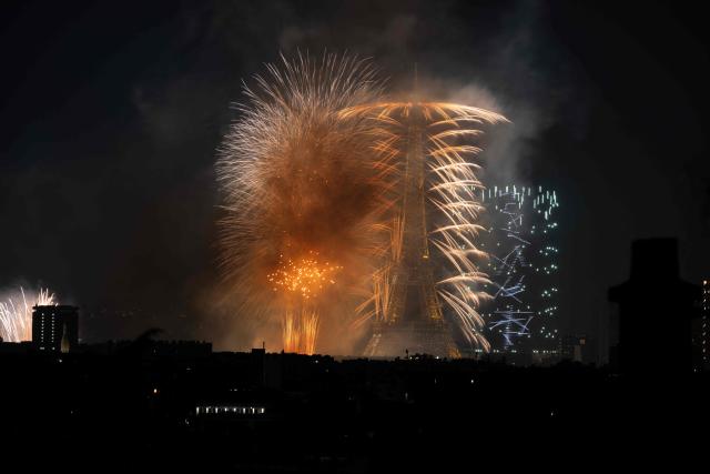 Fireworks light up around the Eiffel Tower during a choreographed firework and drone show to celebrate Bastille Day, in Paris, on July 13, 2026, on the eve of the annual Bastille Day Parade in the French capital. (Photo by Martin BUREAU / AFP)